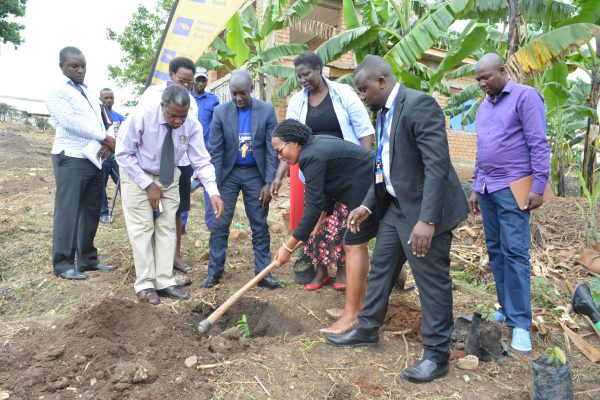 Housing Finance Bank's Ag. Executive Director- Peace Kabunga planting trees at Bishop Stuart University- Mbarara as the Vice Chancellor- Mauda Kamatenesi(third right looks on.)