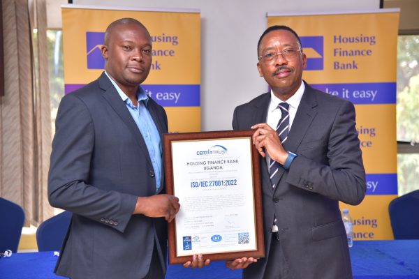 Michael Mugabi holding the ISO certificate together with Mike Kamau the Managing Director of Certi Trust during the handover ceremony at the Bank Head offices in Kololo
