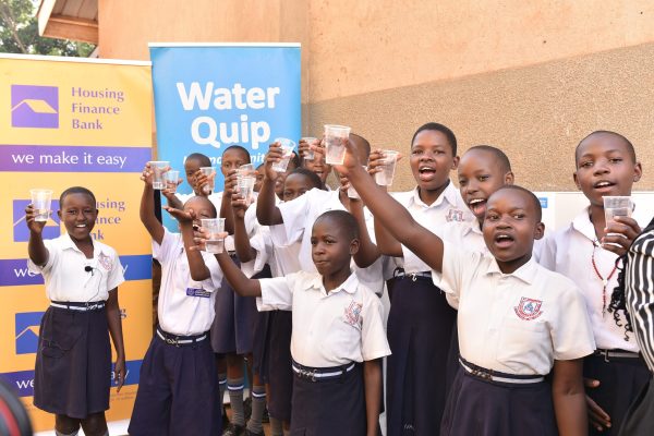 Pupils of St.Joseph Nursery and primary school Nansana celebrate the access of safe drinking water from a water purification system which was commissioned by Housing Finance Bank in partnership with Wa