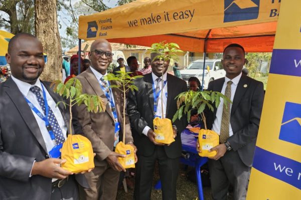 Team from Housing Finance Bank pose for a group photo after a tree planting exercise at Kooki Kingdom, following the receipt of 100 acres