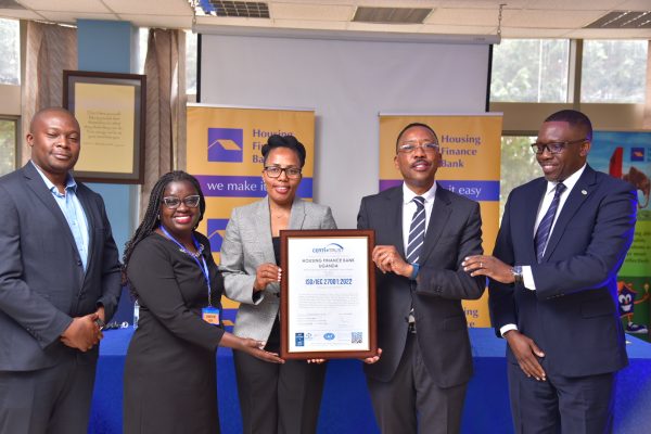 Top Housing Finance Bank and Certi-Trust executives pose for a group photo with the ISO certificate during the handover in Kololo
