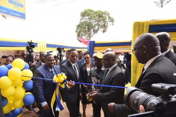 Michael Mugabi, MD HFB and Bosco Bainamazima from BOU (Center) and other Housing Finance Bank executives cut the ribbon during the opening of the new branch in Nansana