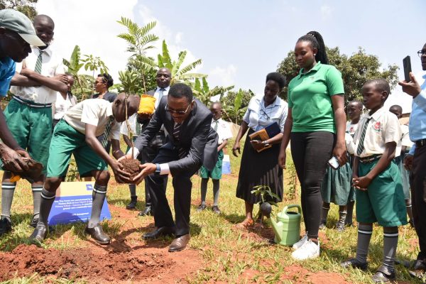 Michael Mugabi - MD Housing Finance Bank and pupils plus the teaching staff at Church of Uganda Kazo Primary School set to plant trees at the school premises